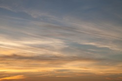 Beautiful sky at sunset, streaked airplane traces. Contrast between warm and cold colors Concept for environmental protection