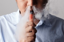 Vaping in Style: A Close-Up of a Male Enjoying an Electronic Cigarette, Producing Thick Clouds of Vapor for a Relaxing and Trendy Experience