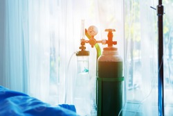 Oxygen tank beside patient bed in hospital.