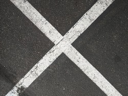 Giant painted white X on asphalt blacktop x marks the spot 