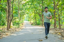 Young man running in the park at morning, also known as jogging or morning walk