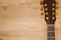 Musical instrument - Neck acoustic guitar on a wooden background. Guitar Head Stock on wooden table with copy space. 8-string Acoustic-electric Baritone Guitar.