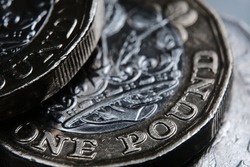 British one Pound coin. The word “One Pound” in a main focus. Macro. Selective focus. Concept.