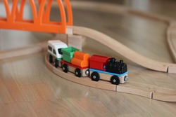 Colored toy cars on wooden rails. Early development of children. Educational toys constructor and steam engine for kids