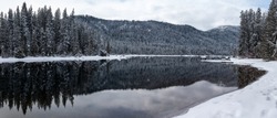 Panorama of Wintry Forest in Mountain Lake