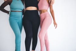 Unrecognizable biracial women with good figure reaching body positive lifestyle-time for together training workout in gym studio, group of multicultural female persons recreating with physical pursuit