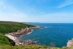 View of the coastline lined with pink sandstone cliffs and the deep blue waters of the Channel in Brittany