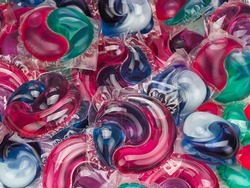 Background of different gel capsules with laundry detergent