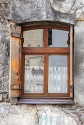 Vintage window with wooden shutters in an ancient stone house.