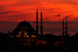 Silhouette of Süleymaniye Mosque on a background of evening red sky. Close-up. Sea of Marmara can be seen behind. View from a height of night Istanbul.