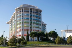 The building of the hotel against the blue sky. Russia Sochi November 2021. Hotel with balconies in the colors of the Olympic flag. Hotel Omega Sirius. Rest in the resort town.