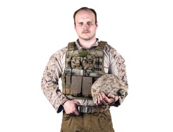 Navy seals\marine veteran posing in front of camera with very serious face. Dressed in tactical battle vest with a knife on a chest, helmet with camo cover in his hands. Isolated, white background.