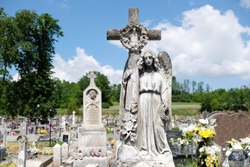 Figure of angel with cross at cemetery in Pelczyska, Ponidzie, Swietokrzyskie, Poland. The sculpture is made of Pinchow limestone (pinchak).