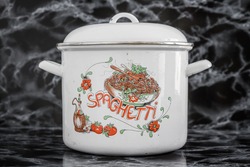 Big white vintage enamel saucepan with spaghetti design on black marble background