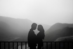 black silhouette teenager man woman lovers couple dating on nature background at the beach and mountain,dark shadow people hug and kiss concept
