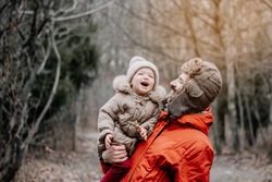 happy family concept. Father and baby daughter playing and laughing on cold winter walk in park