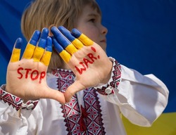 boy in national Ukrainian clothes put forward his painted yellow-blue hands, with inscription STOP War on them. Russia's invasion of Ukraine, Children against war. terrorism on territory of Ukraine