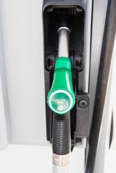 Close up of a gas pump handle. 95 octane number gas, E5 green handle to fuel the car with gas. European Gas station details