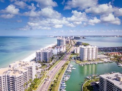 Spring break or Summer vacations in Florida. Ocean beach and Resorts in US. Blue-turquoise color water. American Coast or shore. Island in Gulf of Mexico. Clearwater Beach FL. Aerial view of city.