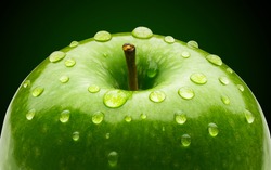 Green apple with water drops on green background. Wet apple. Organic Fresh Granny smith apple. Healthy fruit food. Macro close-up. Food Photography. Good for poster, billboard or backdrop.