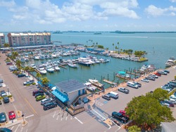 Gulf of Mexico Florida. Sailboat, yacht, boat dock. Aerial view of dock. Boats moored by the pier. Parking lot for cars. Ocean blue-green saltwater. Summer vacations. Dunedin FL USA.