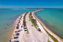 Florida beach. Summer vacations. Panorama of Honeymoon Island State Park. Dunedin FL Causeway. Car parking. Blue-turquoise color of salt water. Ocean or Gulf of Mexico. Aerial view. Seascape photo.