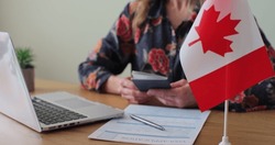 Canadian woman consular officer giving passport to male immigrant, work visa, citizenship. Visa Application online form immigration concept. Visa approval.