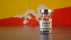Covid Vaccine Bottle with the Bhutan Flag in the Background Corona Vaccine Ampule in front of a Bhutanese Flag
