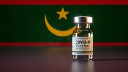 Covid Vaccine Bottle with the Mauritania Flag in the Background Corona Vaccine Ampule in front of a Mauritanian Flag