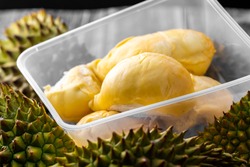 Seasonal Durian king of fruits. Ripe durian. Tasty durian that has been peeled, and some in takeaway box. Food on table concept.
