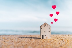 Small model house with heart icon flying abstract background. Home sweet home and lovely family concept. Vintage tone filter effect color style.