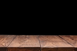 Blank wooden deck table against black wallpaper background for present product and other things. Can be used for your creativity.
