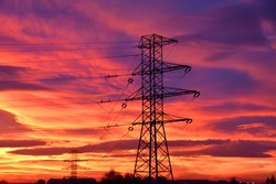 A 20 kV high voltage line traction pole against the background of the iconic red sky picturesque covered with clouds