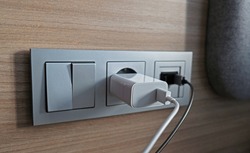 Electrical power socket, usb socket, light switch on the wood panel in the interior of the hotel. For convenience, the mobile charger or smartphone in the concept of modern life. Selective focus.
