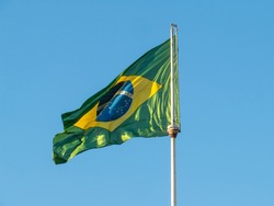 Brazil flag fluttering in the wind. In the center of the flag with the words 