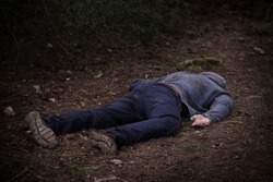 A caucasian man's dead body was found in the park. Murder in the woods. Murdered citizen. Crime scene