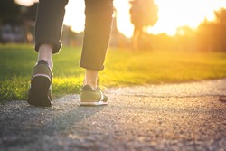 Woman walking in the park, outdoors. Closeup on shoe with rolled up jeans. Taking a step. New life concept