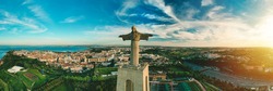 Aerial panoramic view of Sanctuary of Christ the King or Santuario de Cristo Rei at sunset. Christ Statue in Lisbon, Portugal.