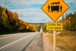 School bus stop ahead road sign. Yellow warning sign on the roadside. Canada's highway