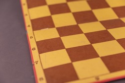 The old chessboard. A worn board for playing checkers or chess. Sports games. Abstract background.
