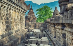the meditating Buddha statue and stone stupas. Ancient Borobudur Buddhist temple. Great religious architecture. Magelang, Central Java, Indonesia
