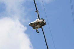 Upward shot of running shoes hanging from electric wires