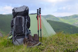 Perfect camping. Close up of backpack rucksack in mountains. Camping equipment concept