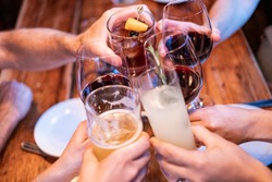People toasting (cheers) with their drinks at a restaurant or bar