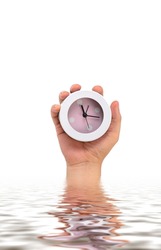 hand holding alarm clock on white and water reflection