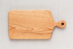 Cherry wood cutting board on linen, handmade wood cutting board