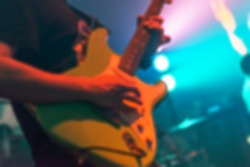 Blur image background of a Man playing guitar. Handsome young men playing guitar on stage with vintage tone colour. 