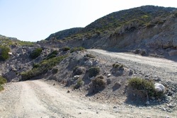 Gravel road to the top of Attavyros mountain. Arid landscape and blue sky. Beautiful hiking area on the island of Rhodes
