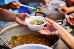 Homeless people are helped with food relief, famine relief : volunteers giving food to poor people in desperate need : The concept of food sharing Help solve Hunger for the homeless