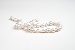 Natural freshwater round pearl beads isolated. String of pearls. Side view.